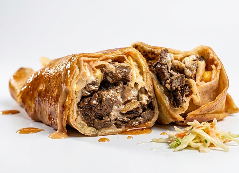 Freshly wrapped Basilissa chicken shawarma with fries and dipping sauce